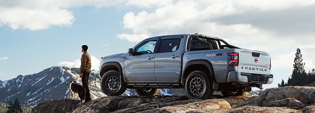 2024 Nissan Frontier back view and a man standing near it