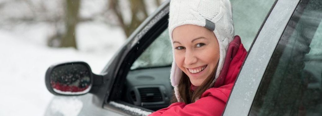 A woman looking outside the window of her car