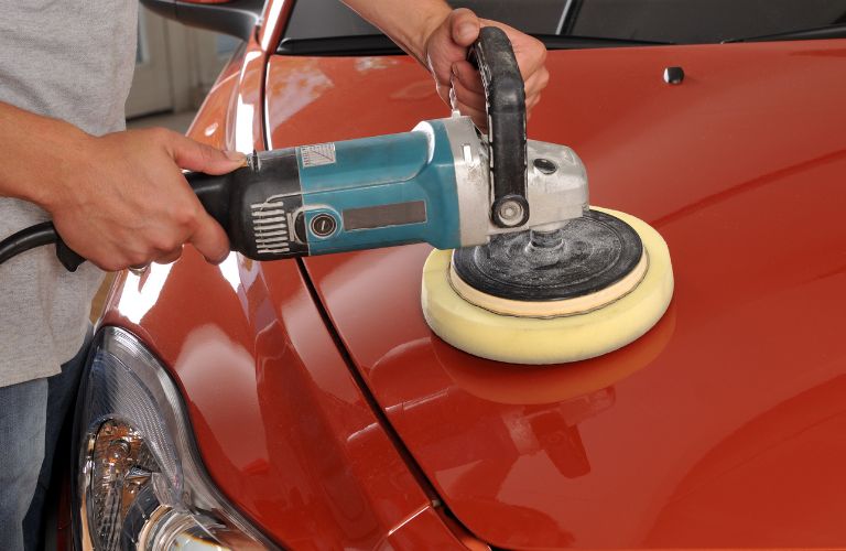 Technician polishing a car