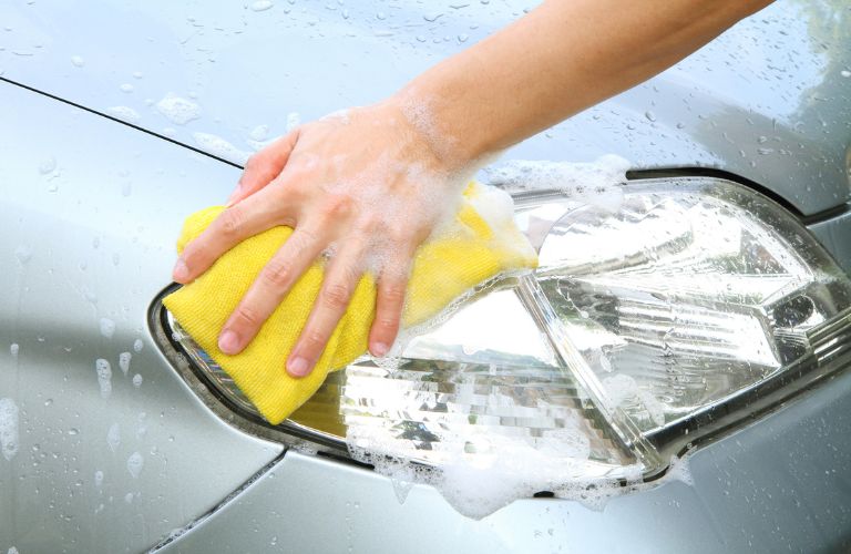 Person washing a car's headlight