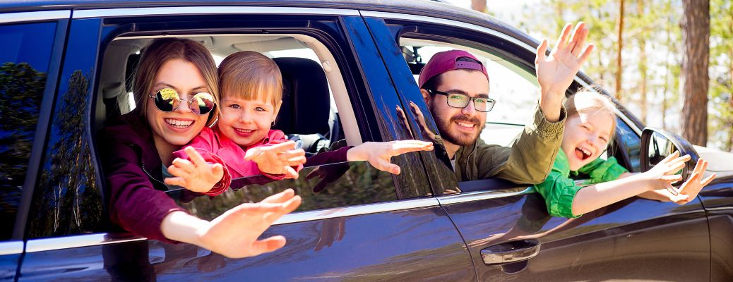 Family of four peeking out of their car windows