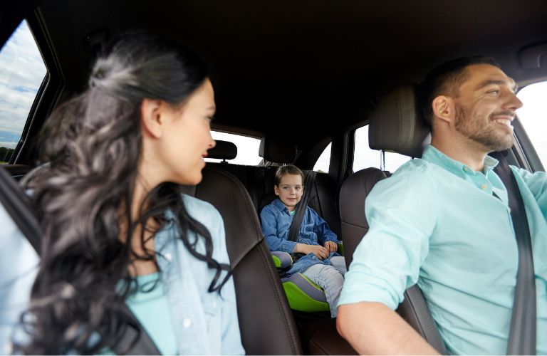 Family of three sitting inside a car