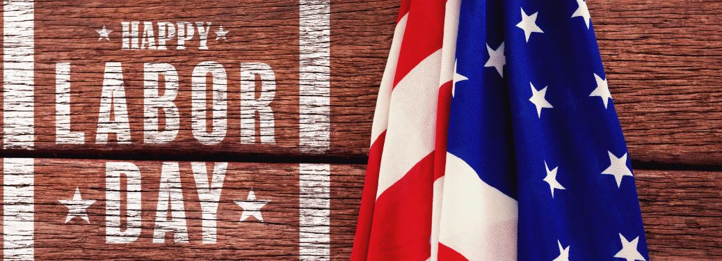 Happy Labor Day, text next to an American Flag on a wooden table