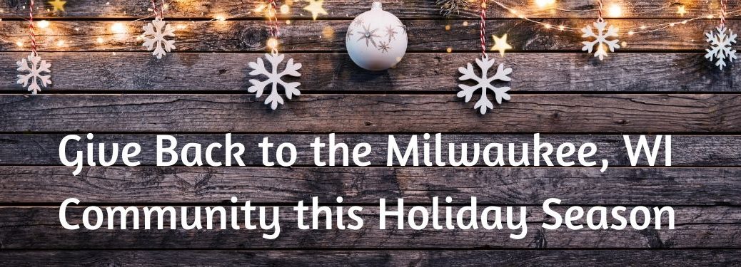Wood table with ornaments and lights on top with text that says Give Back to the Milwaukee, WI community this Holiday Season