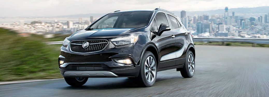 2020 Buick Encore black exterior front fascia driver side driving city in far background