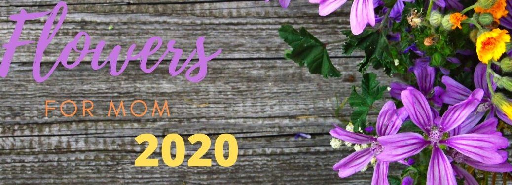Multicolored text reads, "Flowers for Mom 2020" on a background of wood with some flowers laying beside.