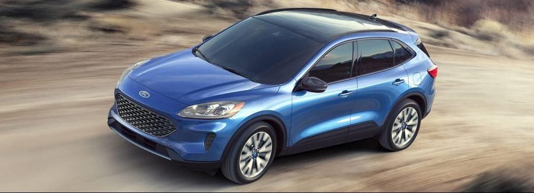 Blue 2020 Ford Escape Hybrid cruises along a desert road