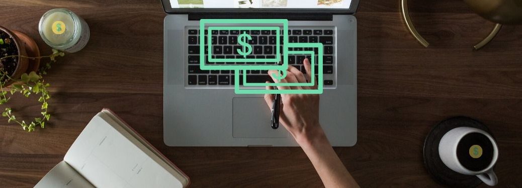 A hand types on a keyboard and money metaphorically pours out of it