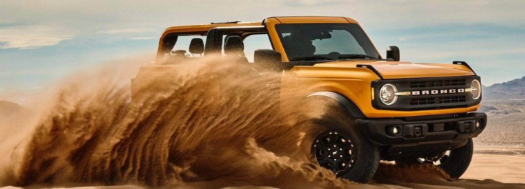 Yellow 2021 Ford Bronco drives through sand