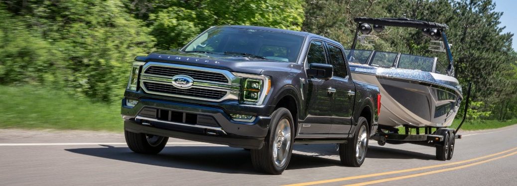 2021 Ford F-150 tows a boat along a highway