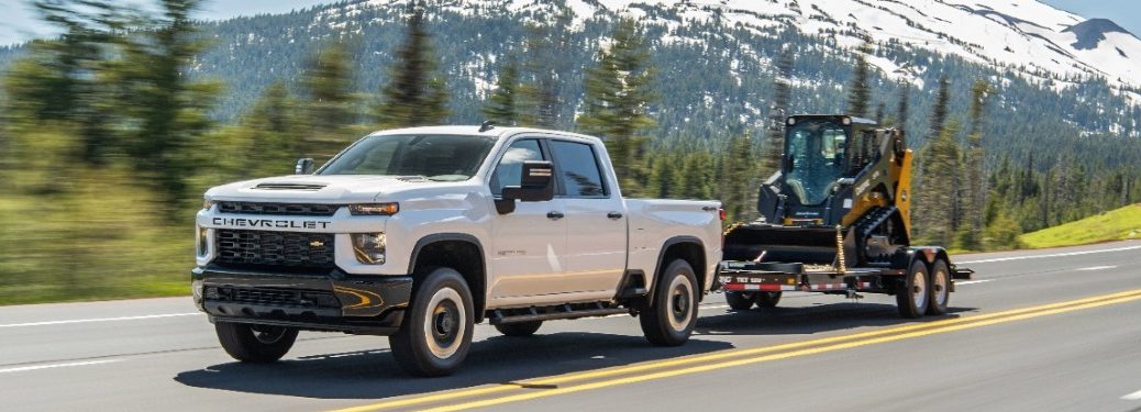 2021 Chevy Silverado HD drives along a highway with a mountain backdrop
