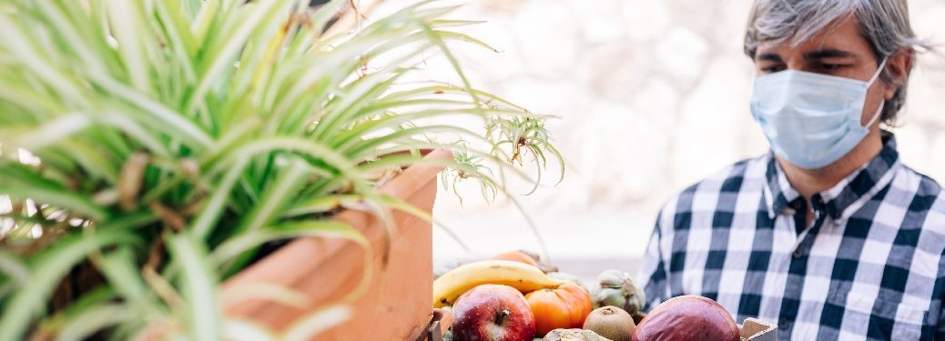 Man in a mask looks at food