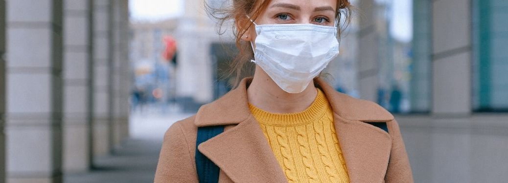 A woman in a city wears a mask