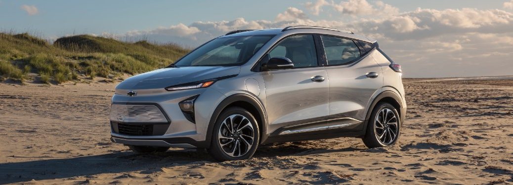 Front driver angle of a silver 2022 Chevrolet Bolt EUV parked in sand
