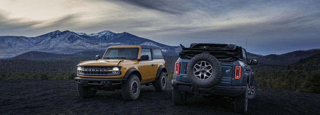 Two Ford Bronco against with a mountain in the background