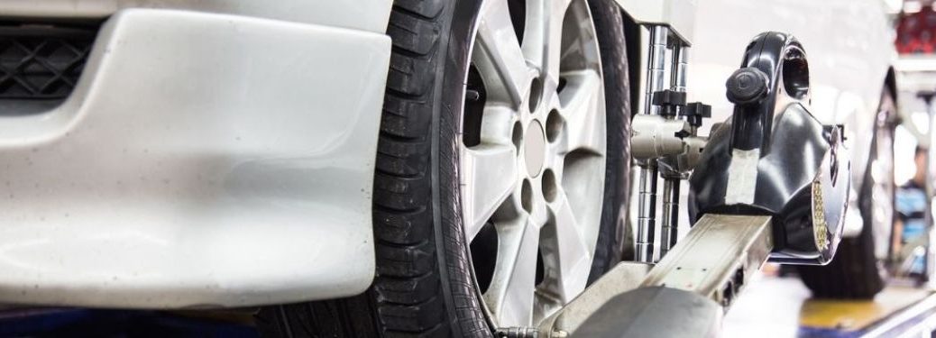 Close up of an auto wheel that is undergoing front-end alignment