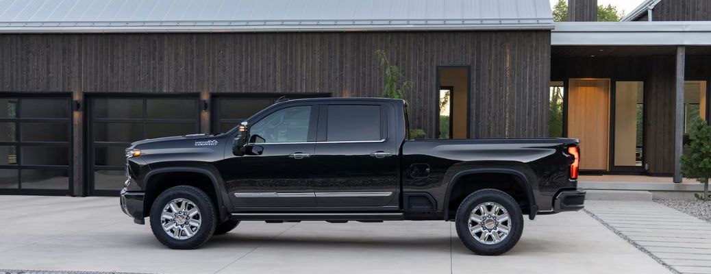 The 2024 Black Silverado HD Displayed Outside of a Modern Ranch Home