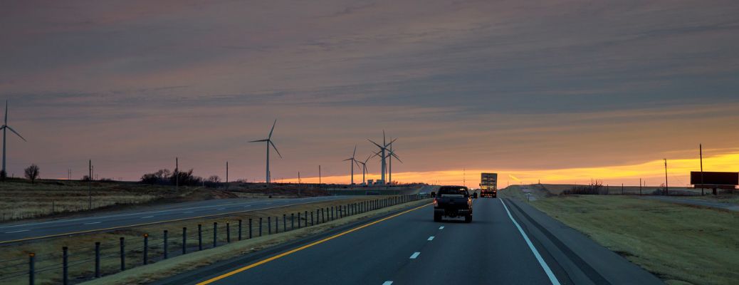 A semi-trailer truck on a road after dark