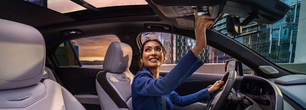 a woman in driving seat opening sunroof of the 2024 Cadillac XT4