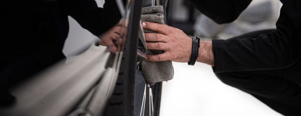 a hand cleaning the exterior of a car