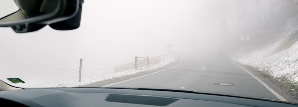 windshield view of a foggy road