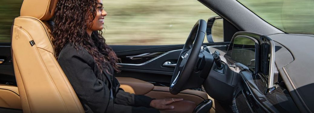 a woman driving a Cadillac hands-free