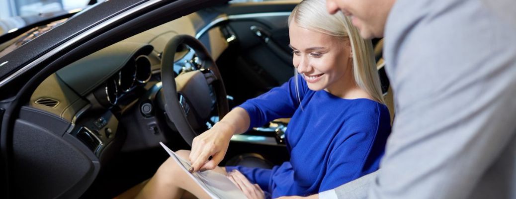 a woman in driving seat checking paperwork