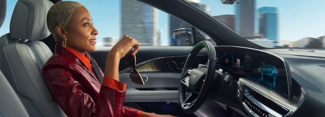 a woman sitting in a Cadillac holding her sunglasses