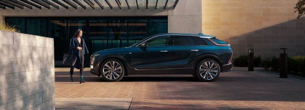 a woman walking towards the 2025 Cadillac LYRIQ