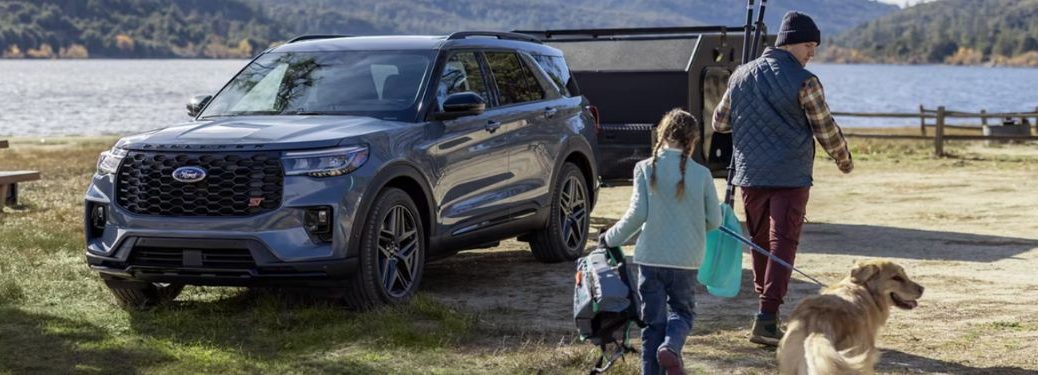 front view of the 2025 Ford Explorer® with a man and young girl holding a dog