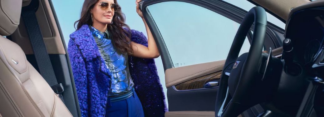 a woman holding the opened door of the 2025 Cadillac XT6