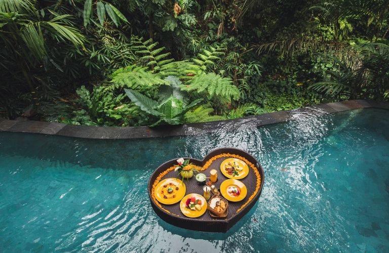 breakfast in a heart-shaped tray in a pool