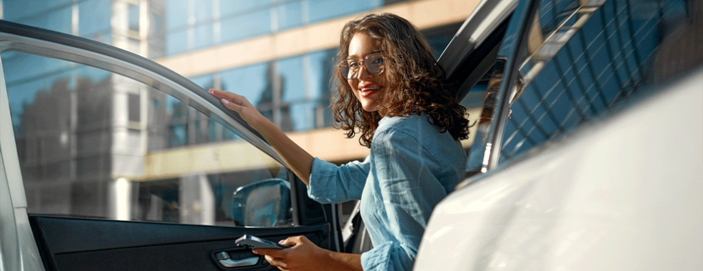 a driver getting out of a car holding her phone