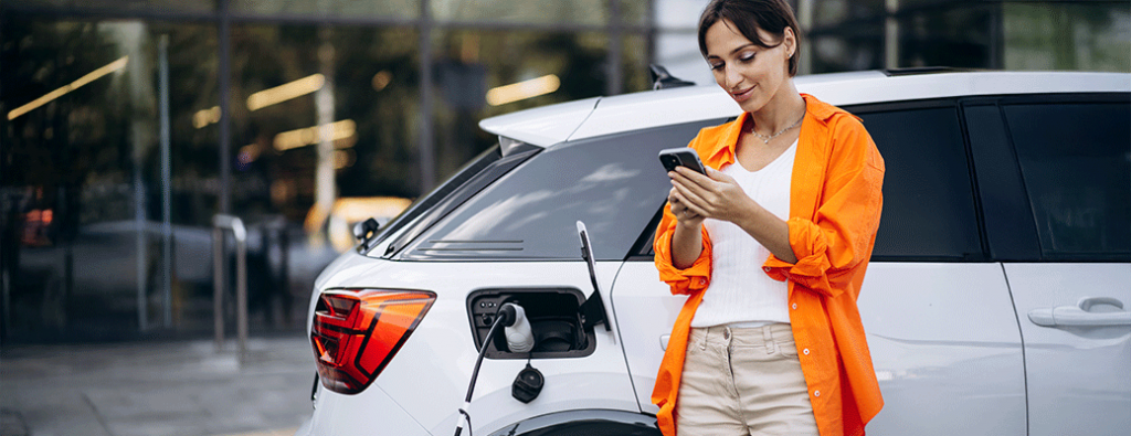 a person holding a phone by a white SUV