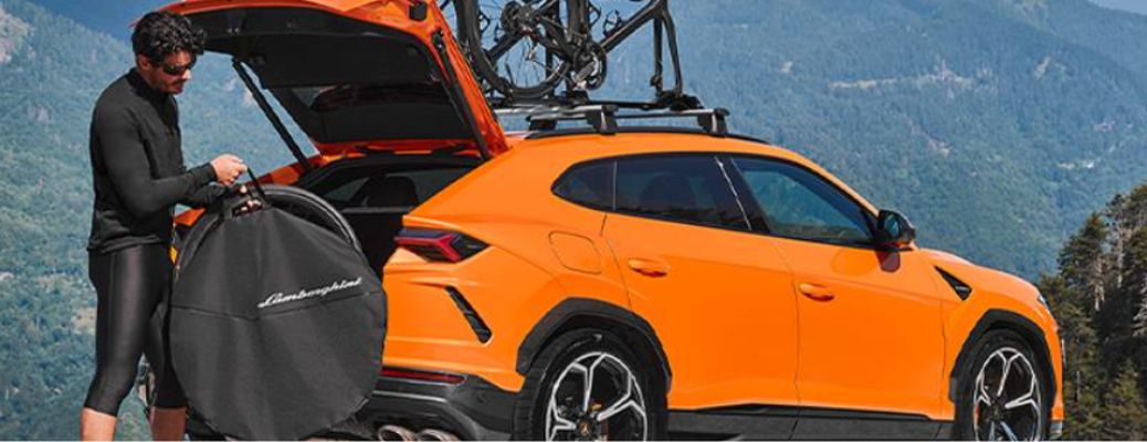 a man loading cargo in a Lamborghini Urus
