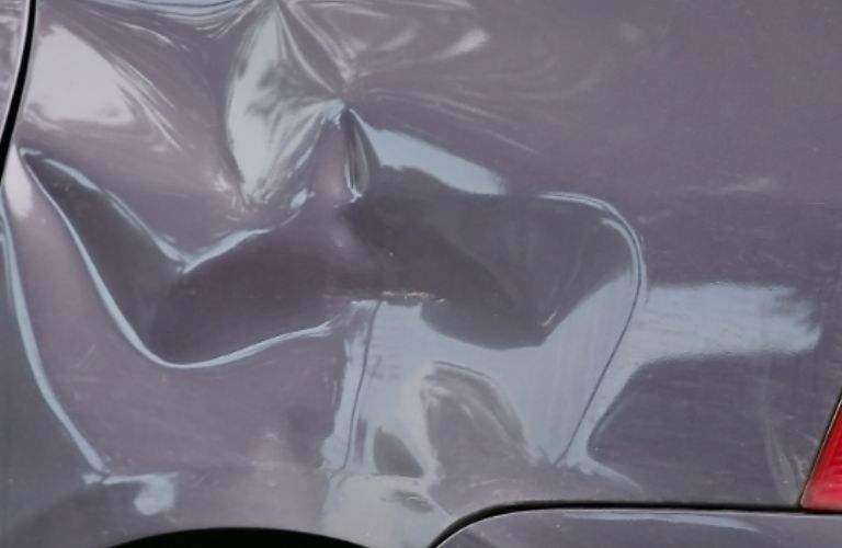 close up of a dent on a car