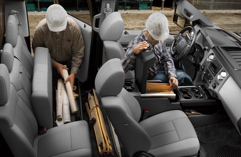 Two workers loading cargo inside 2016 Ford Super Duty