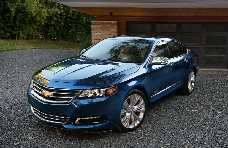 Blue 2018 Chevrolet Impala parked in front of garage