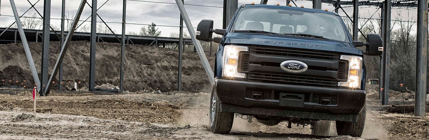 Blue Ford Super Duty driving on worksite