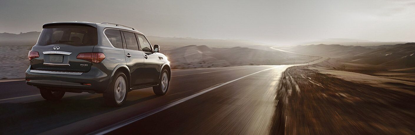 Rear shot of black 2017 INFINITI QX80 driving on desert road