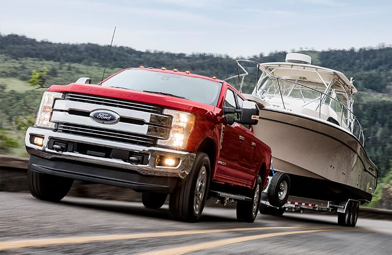 Red 2019 Ford Super Duty F-250 towing trailer on country road