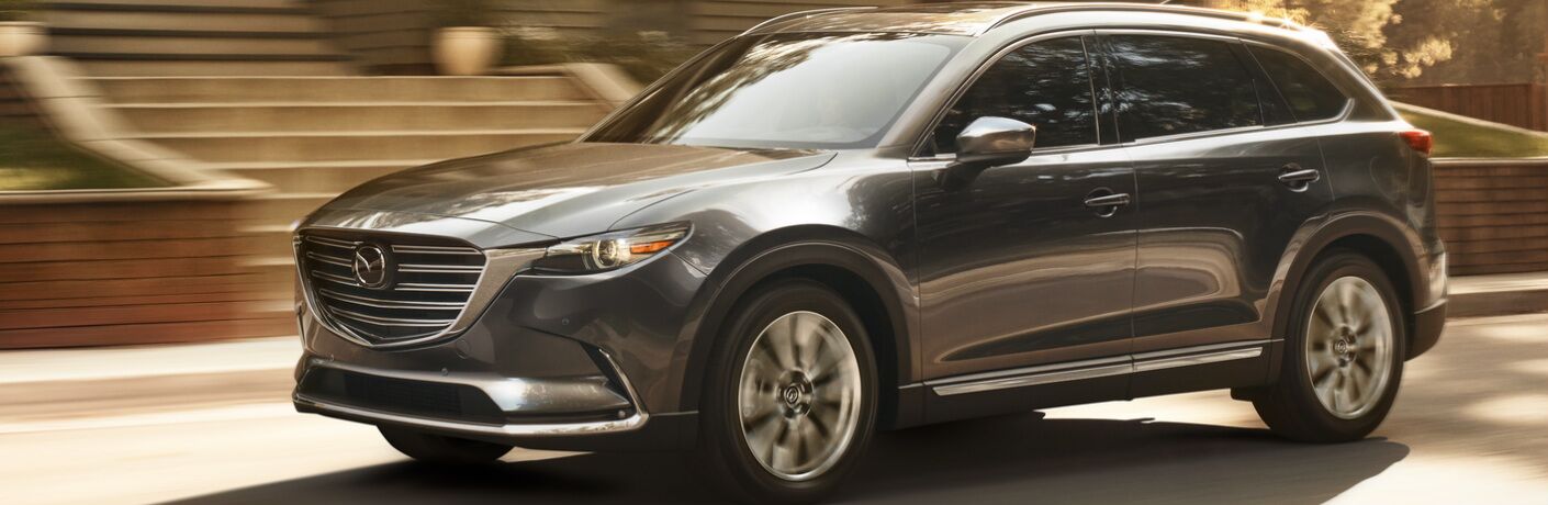 Dark Grey 2019 Mazda CX-9 Driving by a House