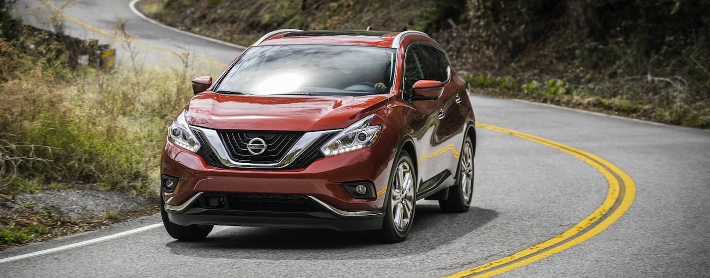 Red 2018 Nissan Murano driving around a bend.