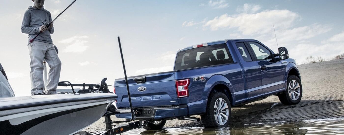 Person fishing near a blue 2019 Ford F-150 XL