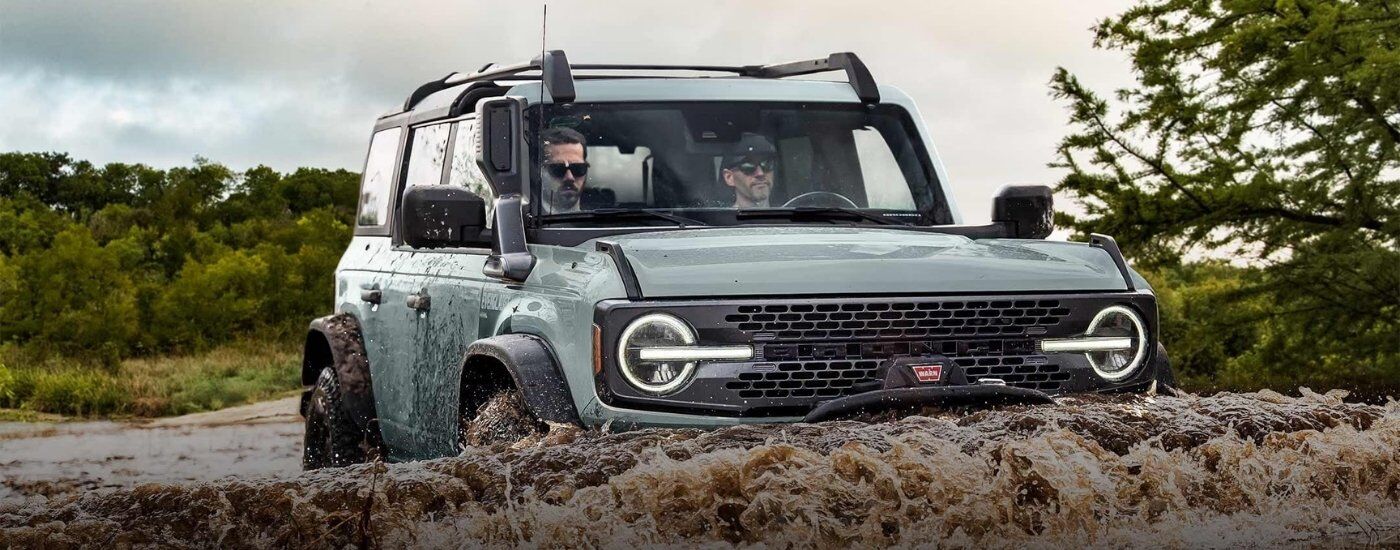 Grey 2022 Ford Bronco Everglades driving through a river