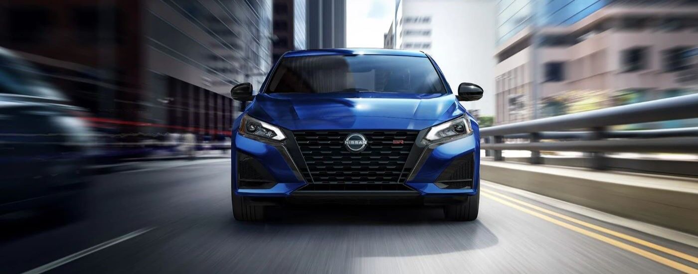Blue 2023 Nissan Sentra SR driving down a city street.
