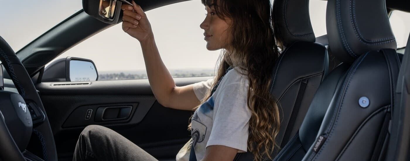Person looking at a vanity mirror in a 2024 Ford Mustang