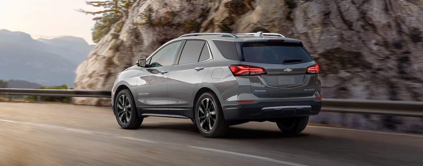 A silver 2023 Chevy Equinox Premier driving on an open road.