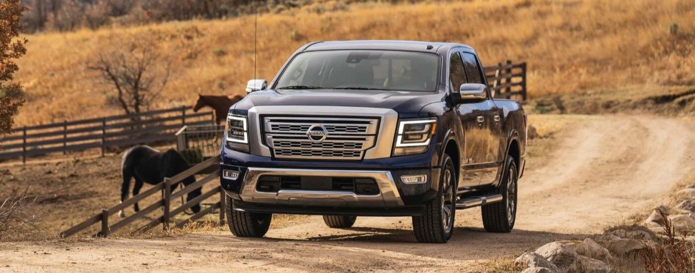 Dark blue 2021 Nissan TITAN driving off-road.