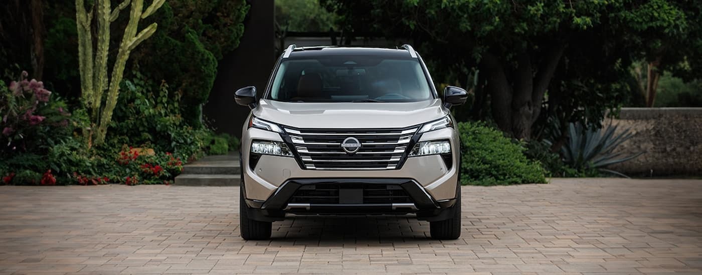 Grey 2025 Nissan Rogue parked on a brick path.